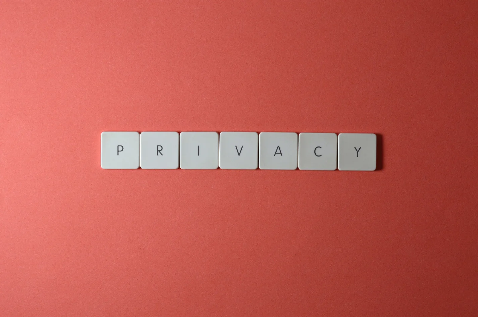 Close-up of letter tiles spelling PRIVACY on a red background, symbolizing data protection.